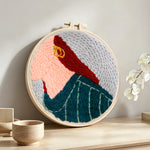 Stylish red-haired lady punch needle artwork displayed on a table