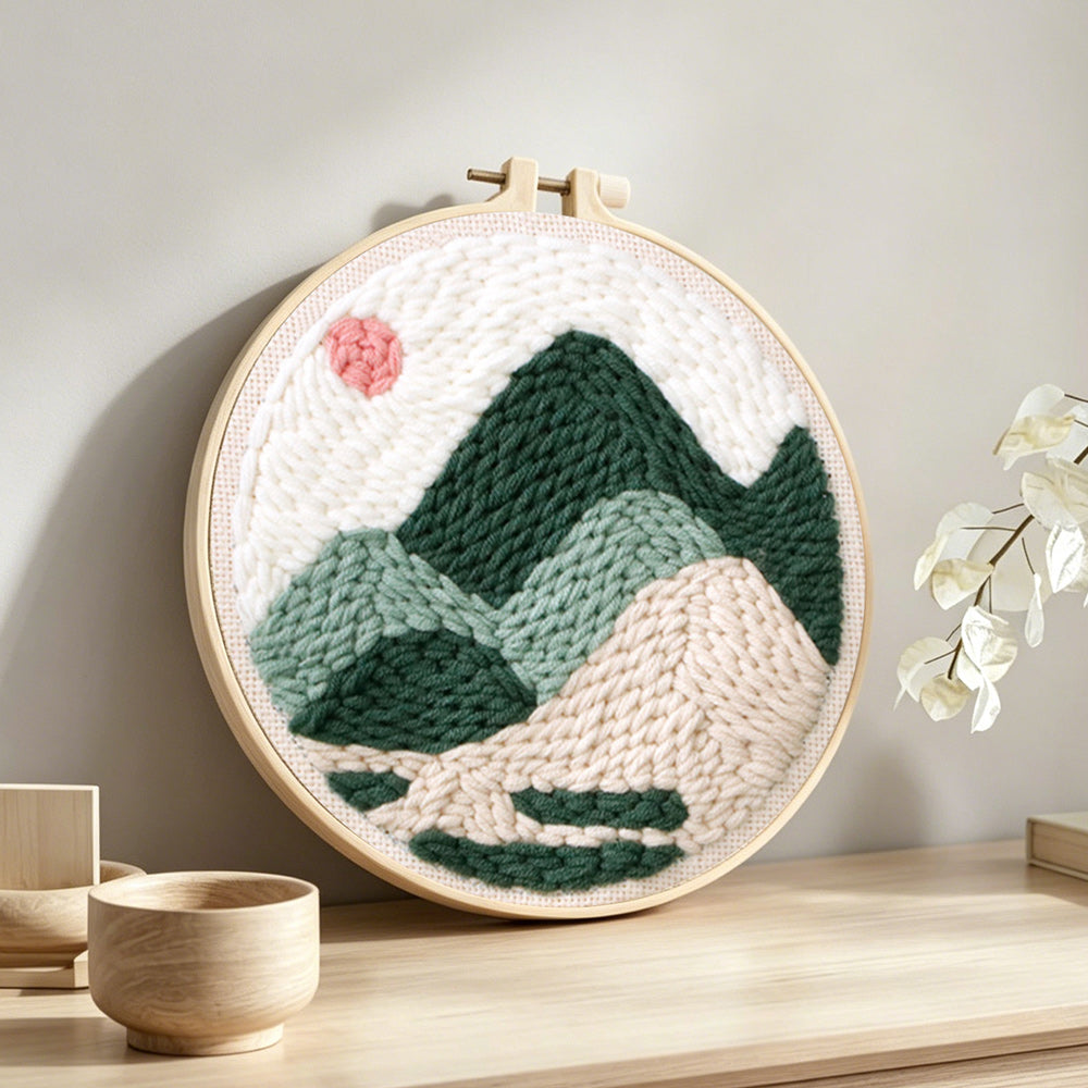 Summer mountain scene with sun punch needle artwork displayed on a table