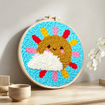 Sun and cloud with rainbow rays punch needle artwork displayed on a table