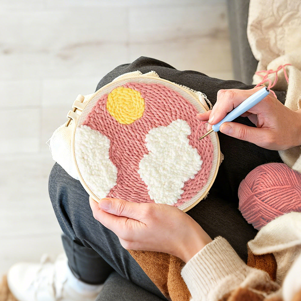 Creating handmade sun and clouds in pink sky punch needle artwork