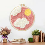 Finished sun and clouds in pink sky artwork displayed on a wall
