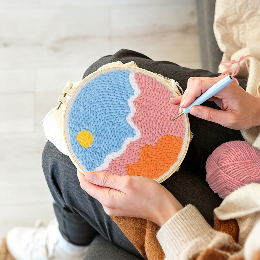 Creating handmade sun over colourful clouds punch needle artwork