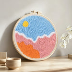 Sun over colourful clouds punch needle artwork displayed on a table