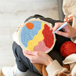 Creating handmade sun over colourful mountains punch needle artwork