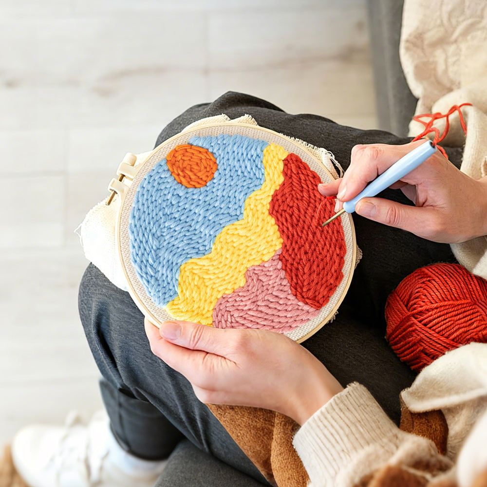 Creating handmade sun over colourful mountains punch needle artwork
