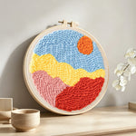 Sun over colourful mountains punch needle artwork displayed on a table