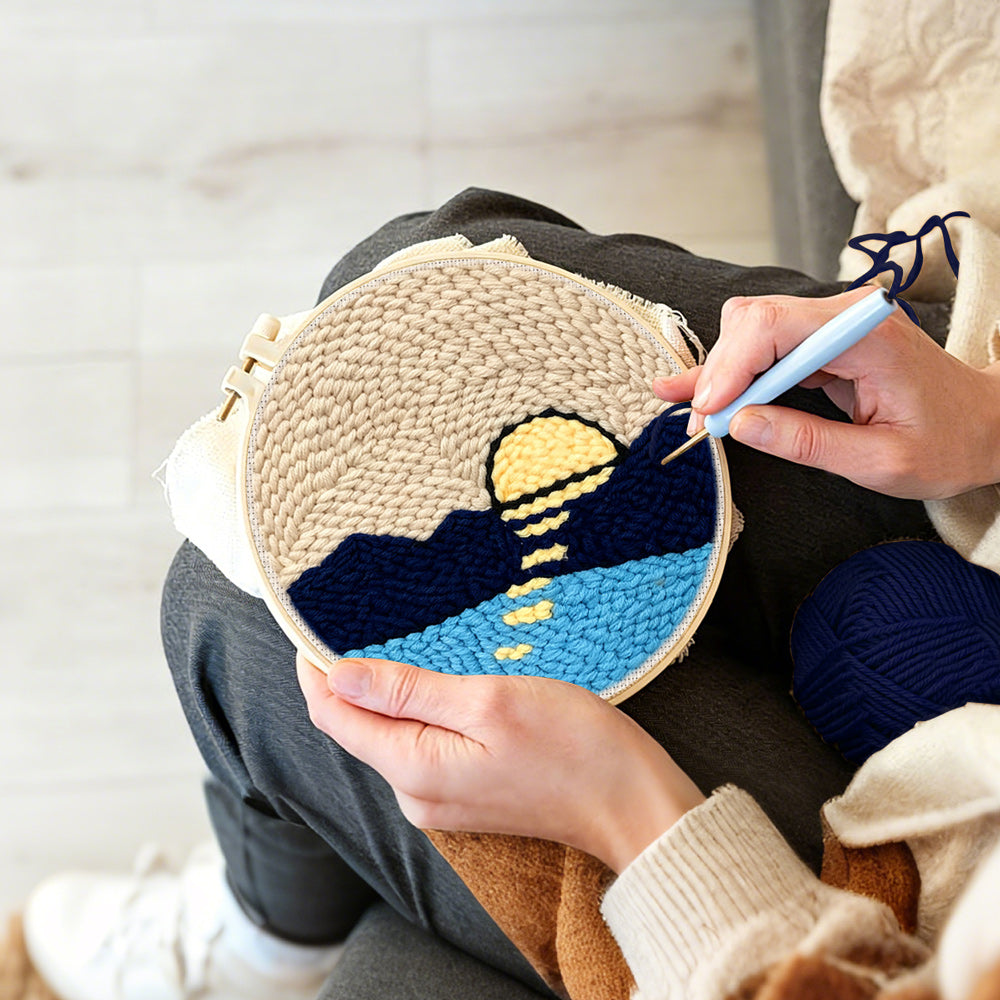 Creating handmade sun over mountains and water punch needle artwork