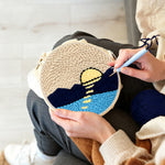 Creating handmade sun over mountains and water punch needle artwork