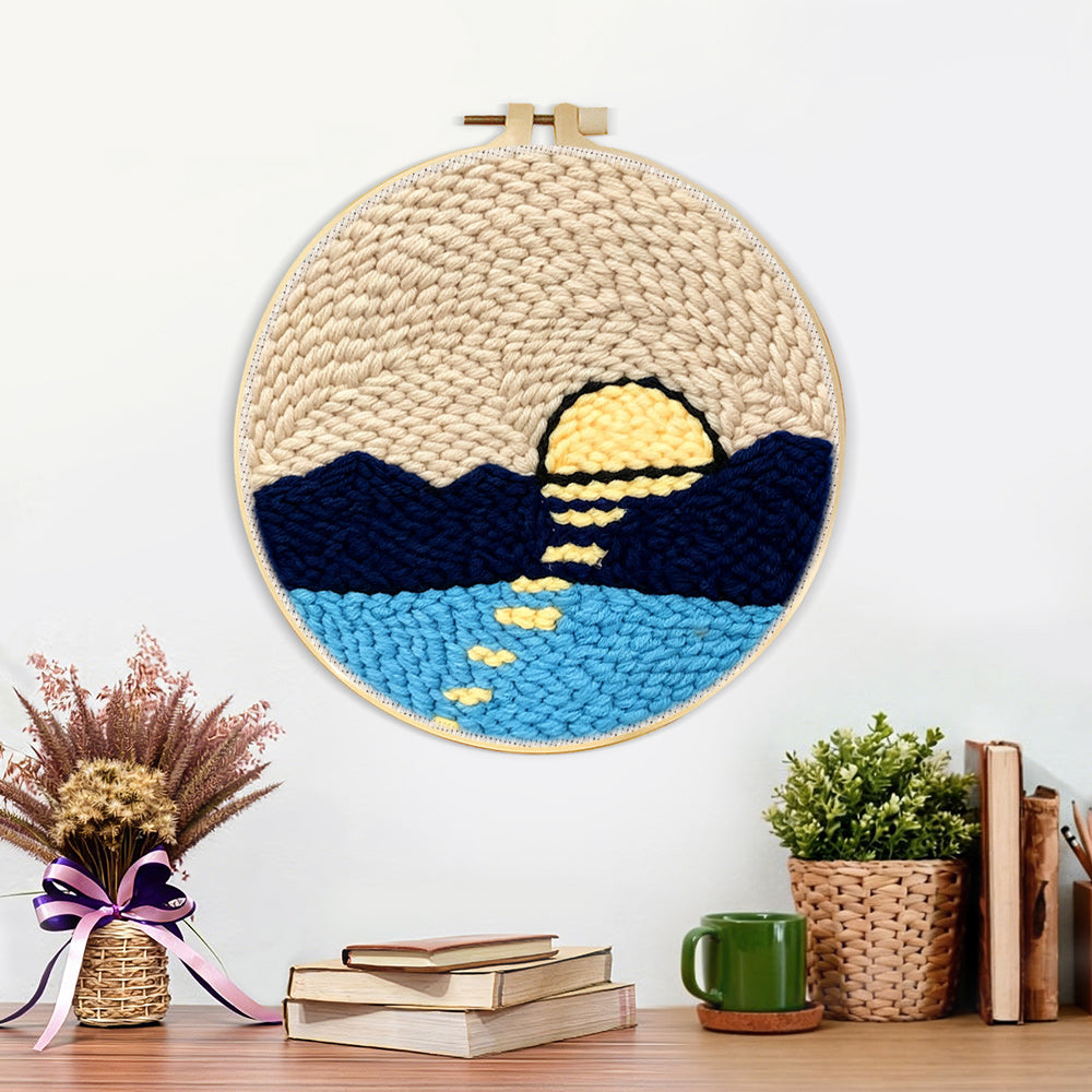 Finished sun over mountains and water artwork displayed on a wall