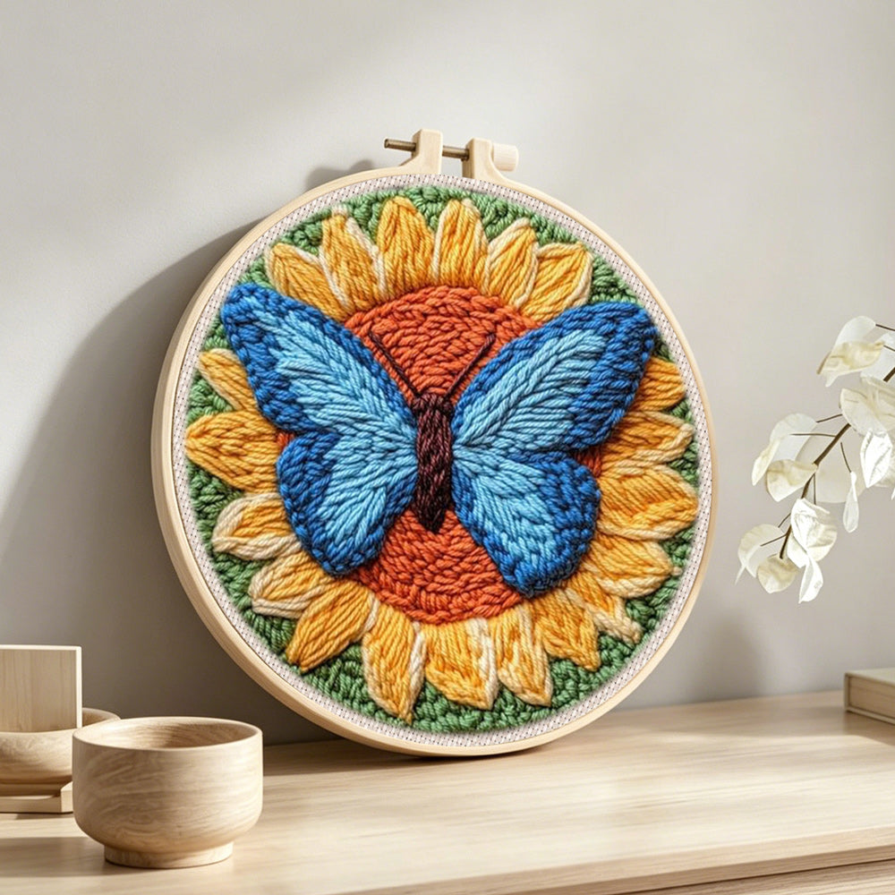 Sunflower and blue butterfly punch needle artwork displayed on a table