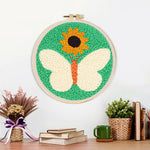 Finished sunflower and white butterfly artwork displayed on a wall