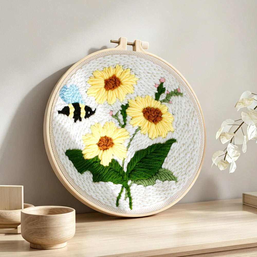 Sunflowers and buzzing bee punch needle artwork displayed on a table