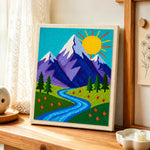 Sunny mountain and blue meandering stream punch needle artwork displayed on a table