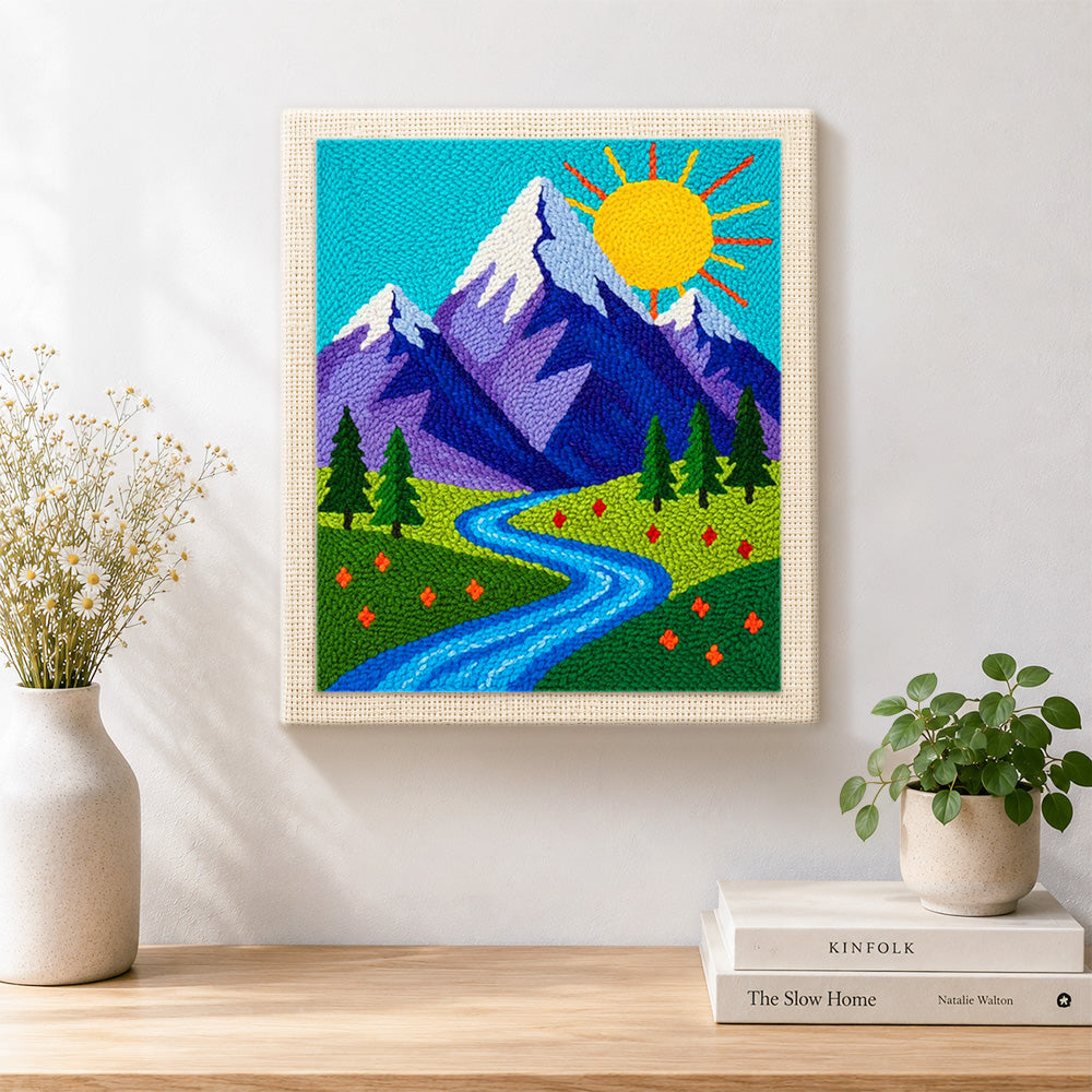 Finished sunny mountain and blue meandering stream artwork displayed on a wall