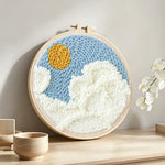 Sunny sky with clouds punch needle artwork displayed on a table