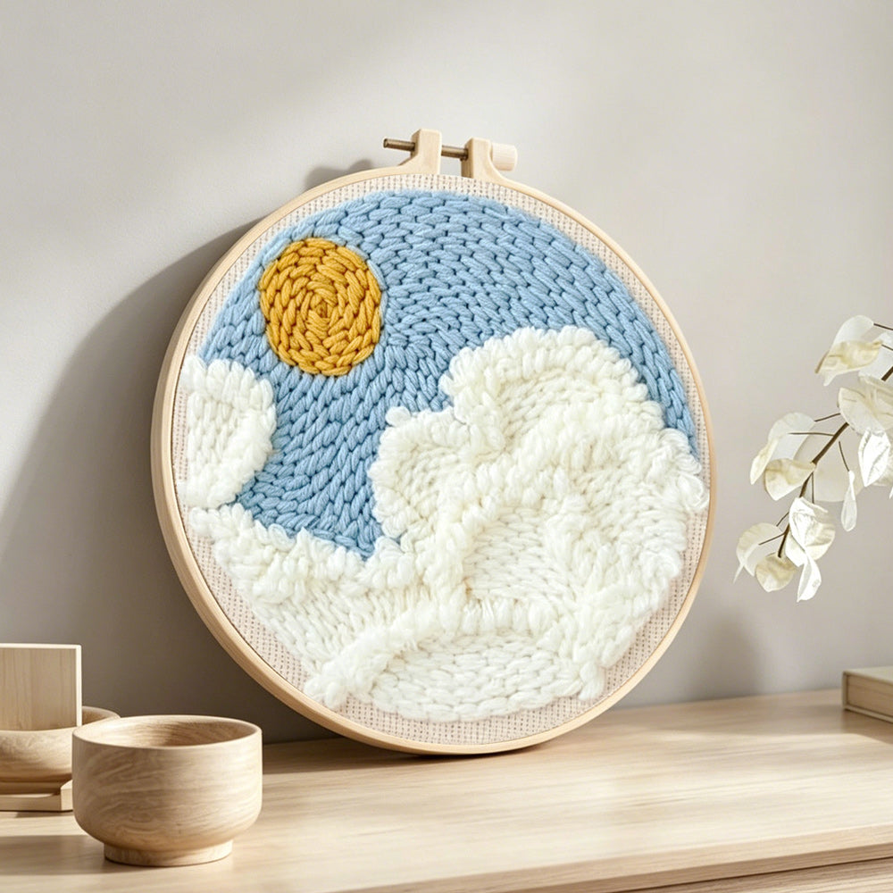 Sunny sky with clouds punch needle artwork displayed on a table