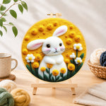 Finished sunny white bunny and yellow flowers needle felting displayed on a wooden easel