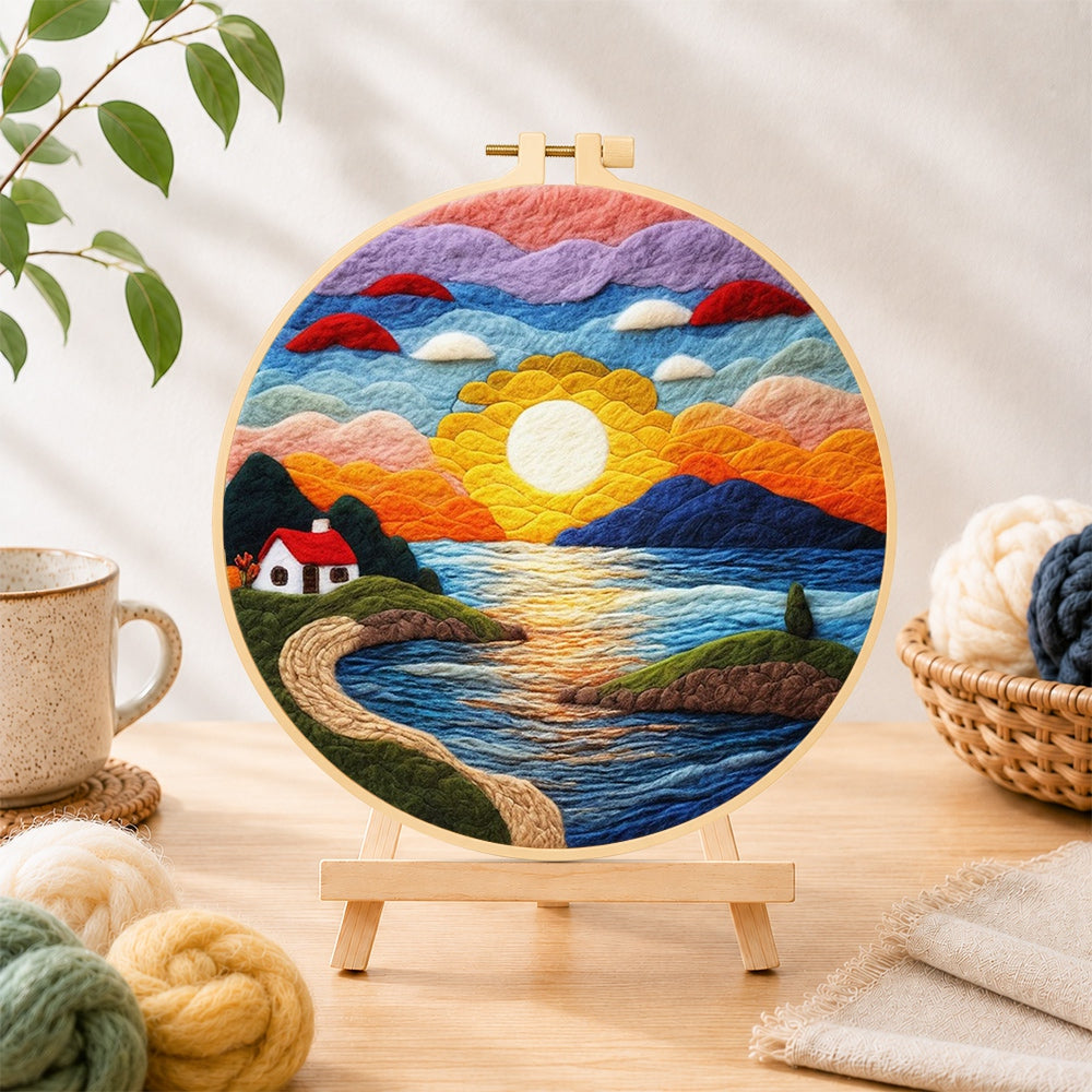 Finished sunset and seaside cottage needle felting displayed on a wooden easel