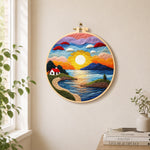 Sunset and seaside cottage needle felt wall art displayed in a bright home interior