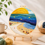 Finished sunset beach and blue rolling waves needle felting displayed on a wooden easel