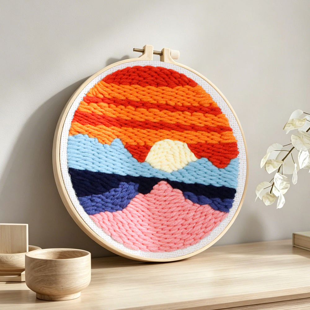 Sunset over ocean punch needle artwork displayed on a table