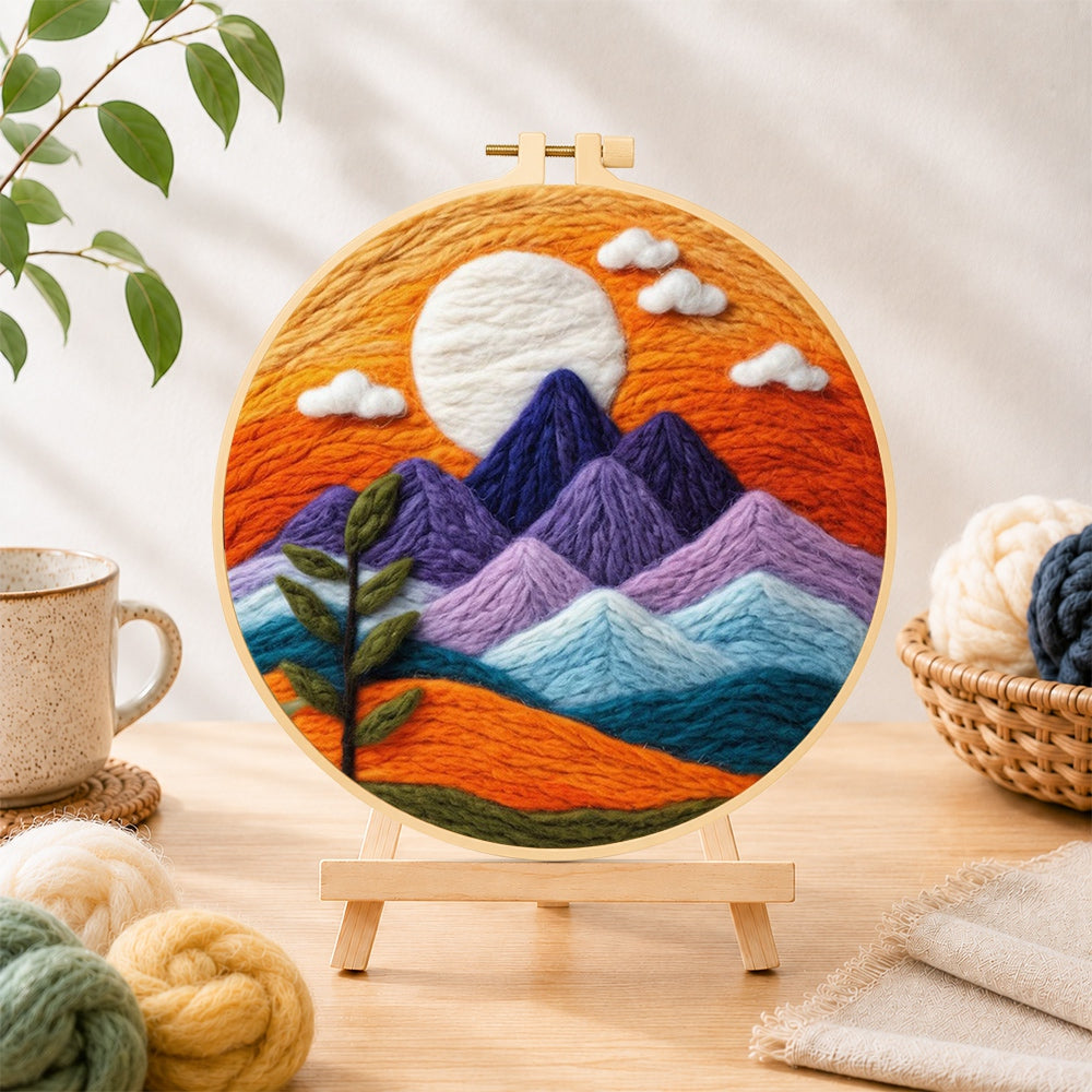 Finished sunset purple mountains and green sprig needle felting displayed on a wooden easel