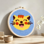Super happy cat punch needle artwork displayed on a table