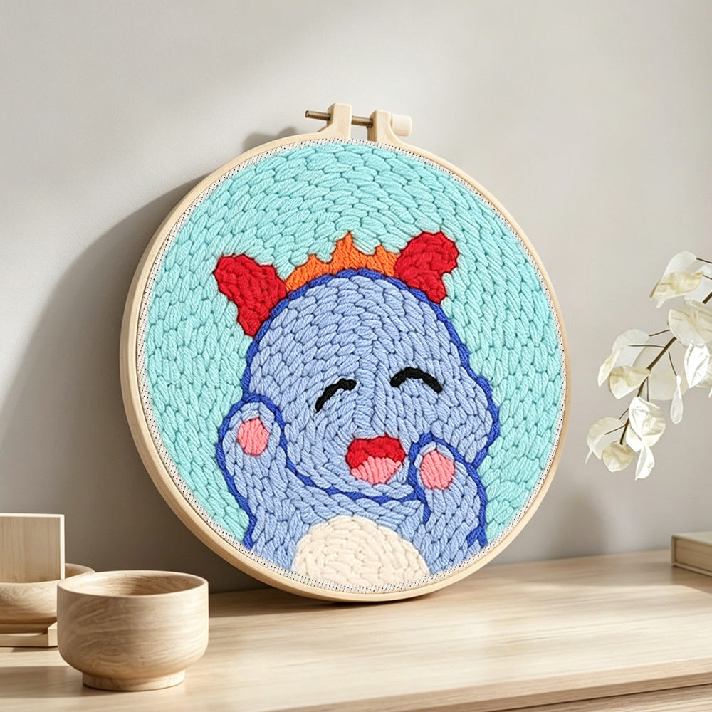 Sweet baby dinosaur punch needle artwork displayed on a table