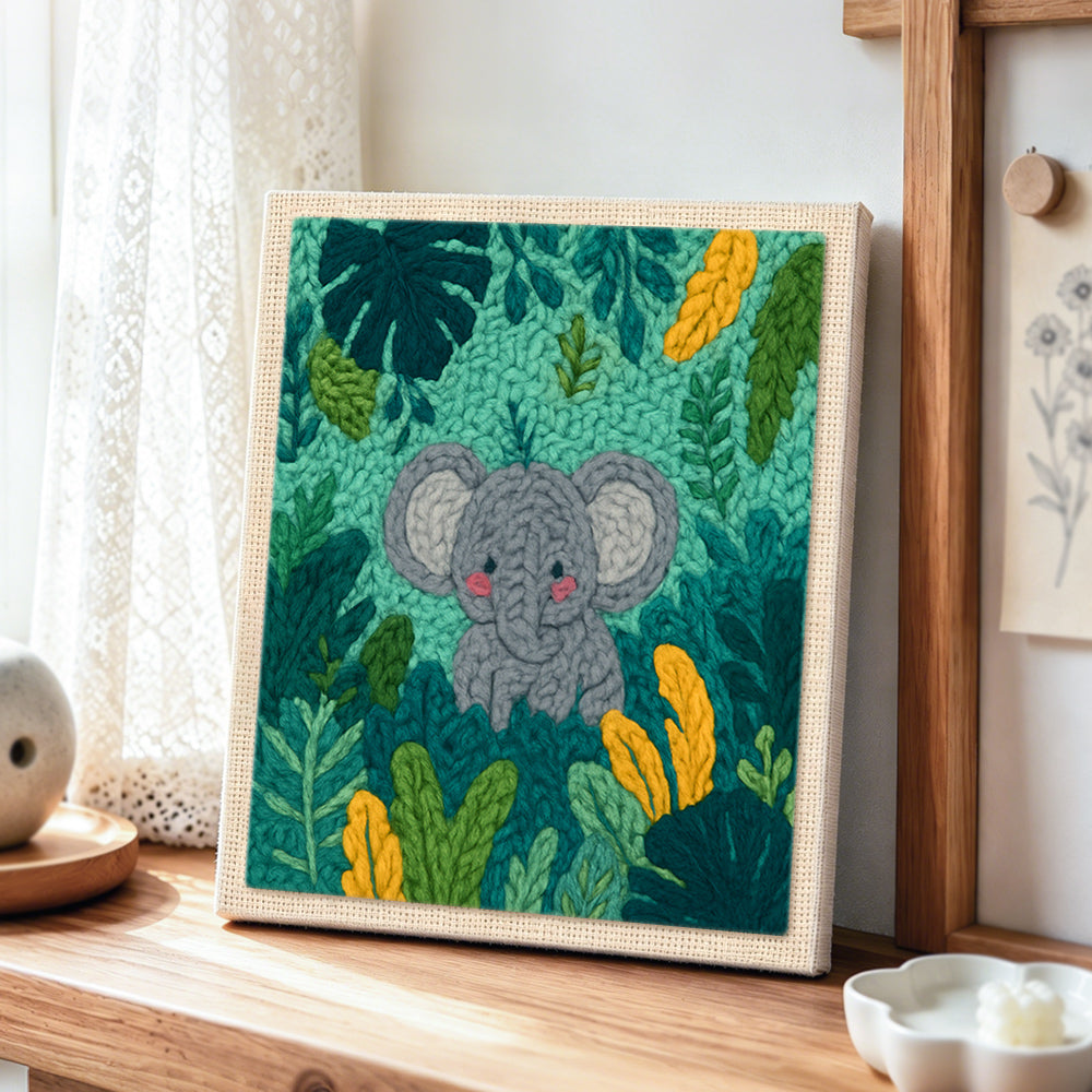 Sweet baby elephant in tropical leaves punch needle artwork displayed on a table