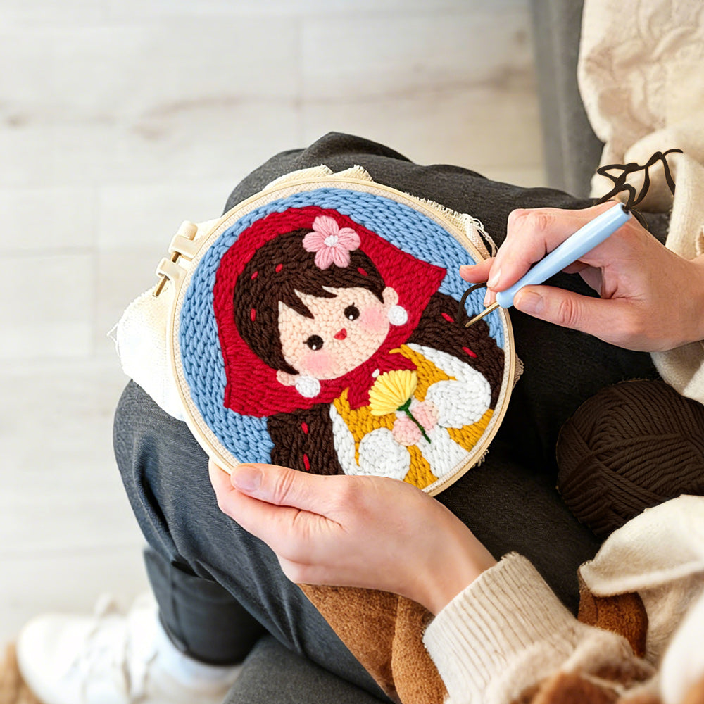 Creating handmade sweet girl in red scarf holding flowers punch needle artwork