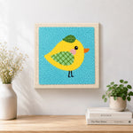 Finished sweet little yellow bird with green wing artwork displayed on a wall