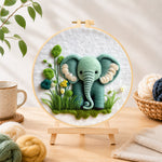 Finished sweet mint green elephant and plants needle felting displayed on a wooden easel
