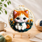 Finished sweet orange and white kitten needle felting displayed on a wooden easel