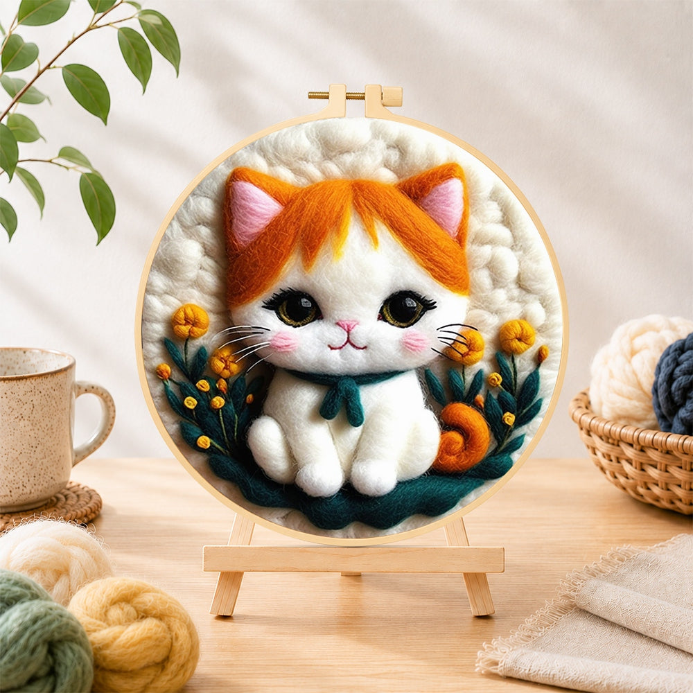 Finished sweet orange and white kitten needle felting displayed on a wooden easel