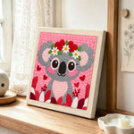 Sweet pink koala with heart flower crown punch needle artwork displayed on a table