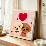 Sweet puppies under a heart punch needle artwork displayed on a table