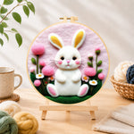 Finished sweet white bunny and pink flowers needle felting displayed on a wooden easel