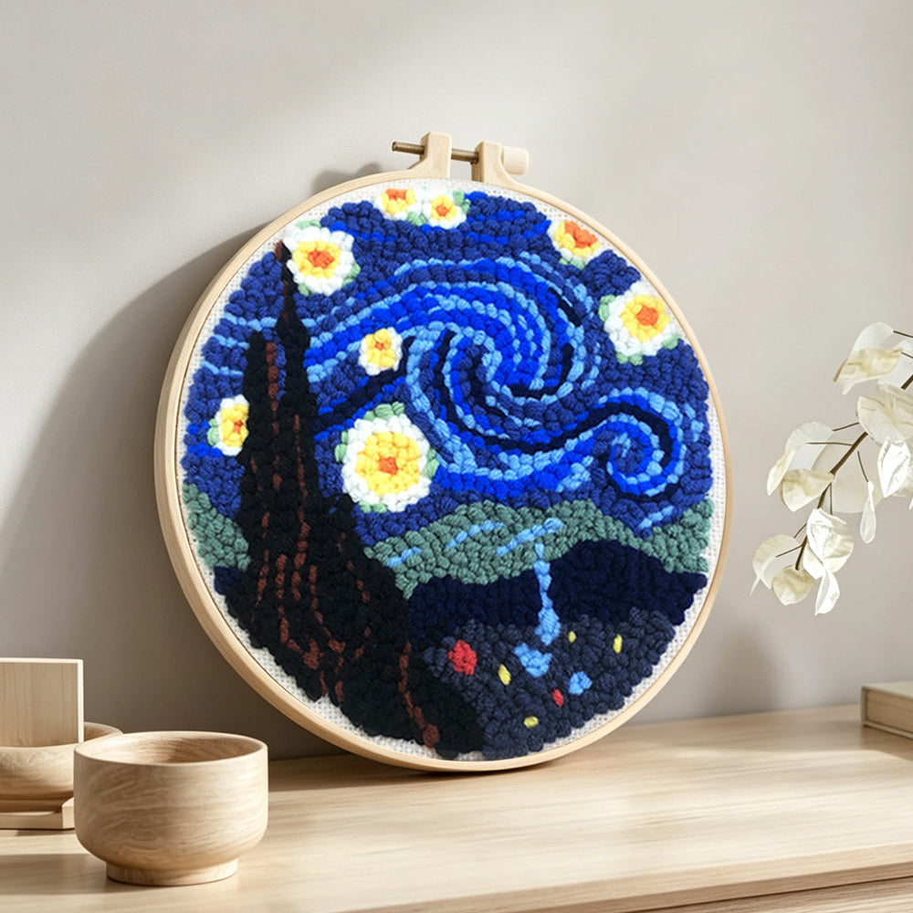 Swirling blue night sky with glowing stars punch needle artwork displayed on a table