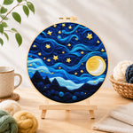 Finished swirling night sky with stars and blue clouds needle felting displayed on a wooden easel