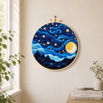 Swirling night sky with stars and blue clouds needle felt wall art displayed in a bright home interior