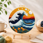 Finished swirling ocean and sunset needle felting displayed on a wooden easel