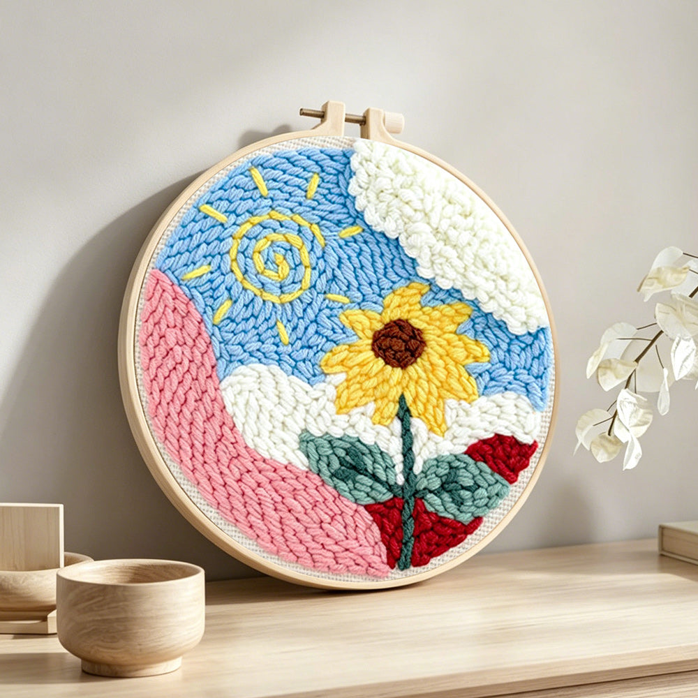 Swirly sun and cheerful sunflower punch needle artwork displayed on a table