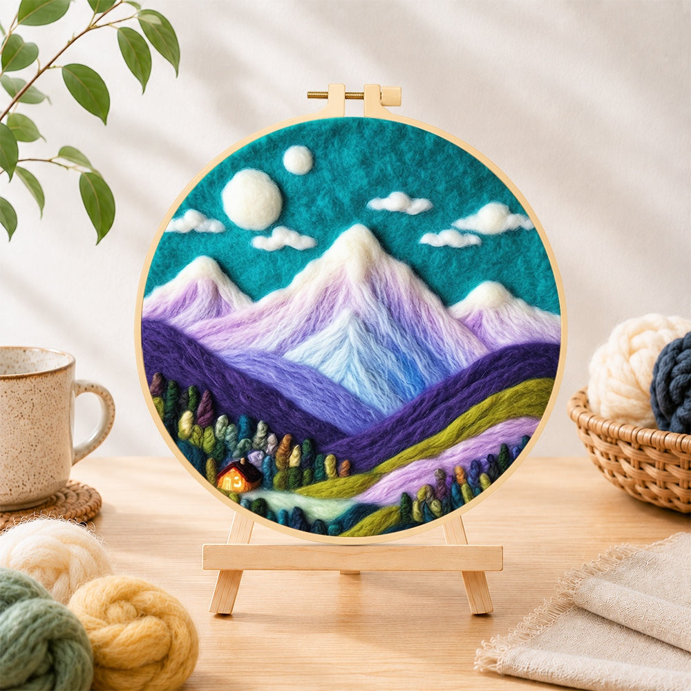 Finished teal sky and purple mountains needle felting displayed on a wooden easel