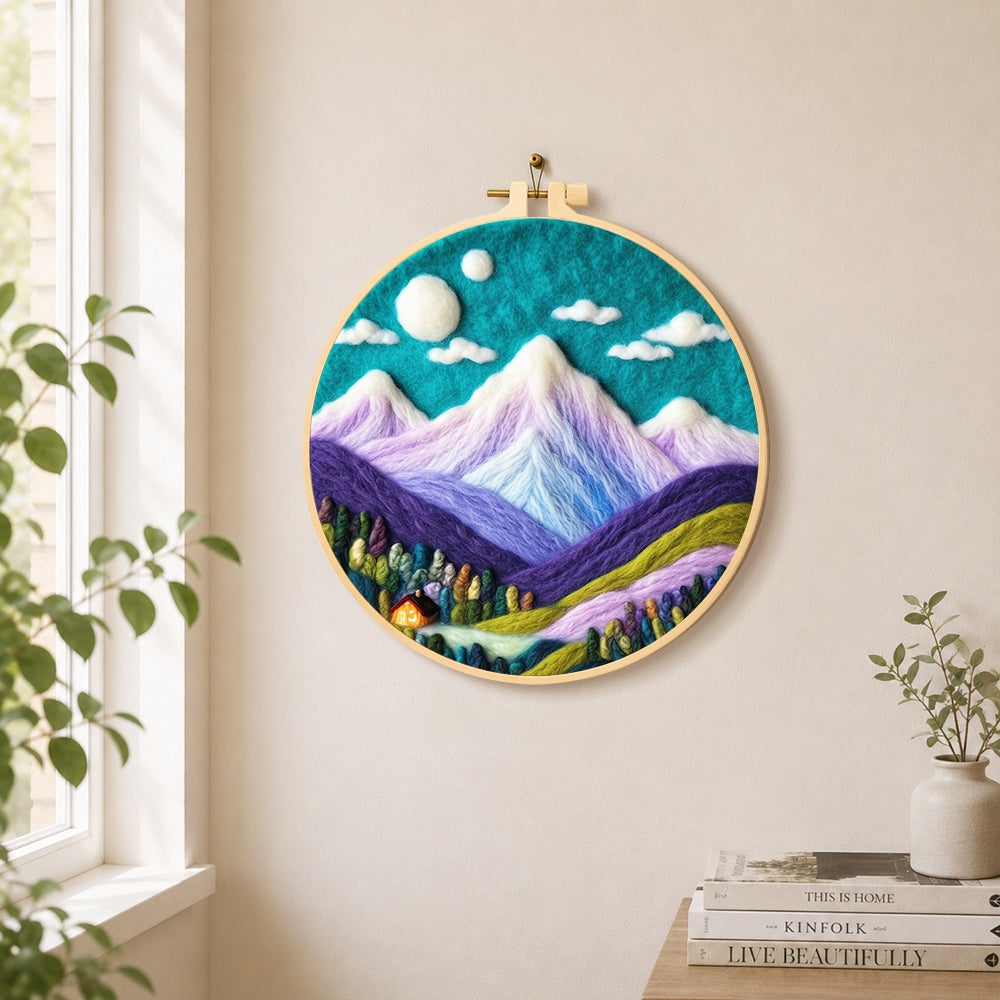 Teal sky and purple mountains needle felt wall art displayed in a bright home interior