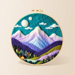 Teal sky and purple mountains needle felting kit for beginners with a round wooden frame
