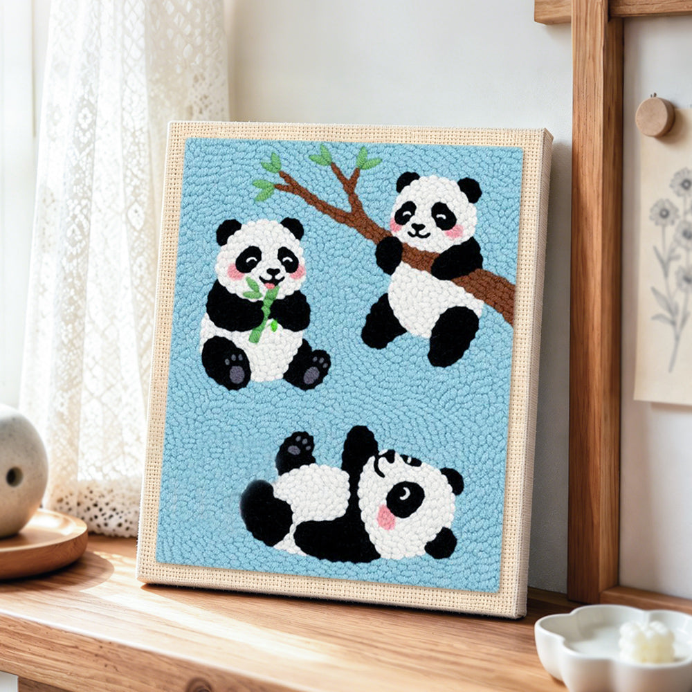 Three playful pandas punch needle artwork displayed on a table