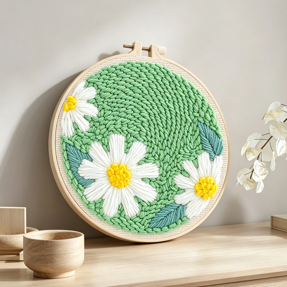 Three pure white daisies punch needle artwork displayed on a table