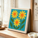 Three simple yellow sunflowers punch needle artwork displayed on a table