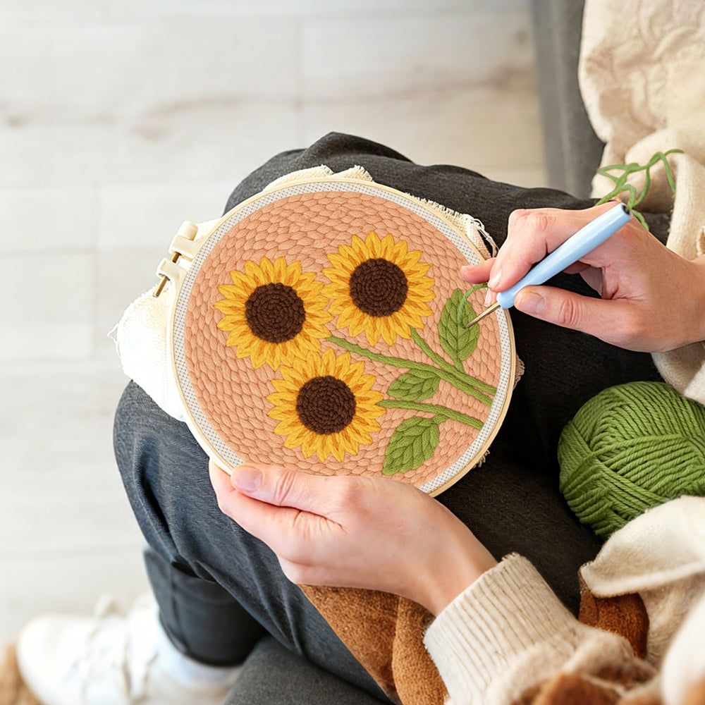 Creating handmade three sunflowers on peachy pink punch needle artwork