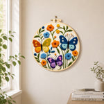 Three whimsical butterflies among flowers needle felt wall art displayed in a bright home interior